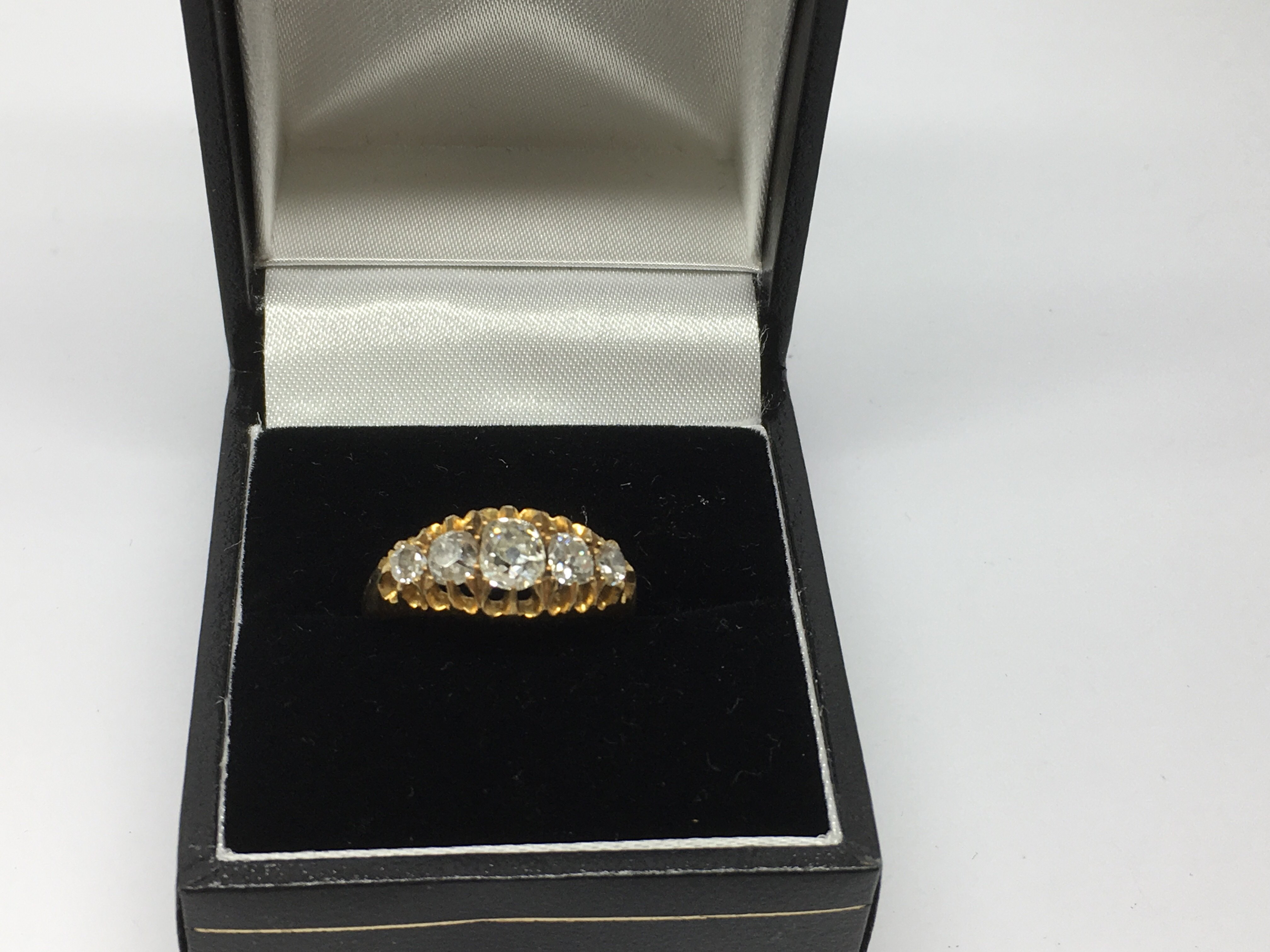 An 18ct gold ring set with a band of diamonds.Approx L, 3.86g.Sold with single glass stone