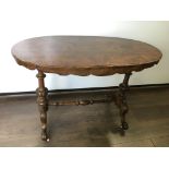 A Victorian, burr walnut occasional table on turned carved columns united by turned stretcher on