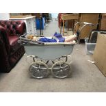 A Triang pram with hood and a doll. Pram approximately 56cm tall. Doll approximately 60cm tall -