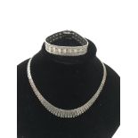 A silver collar necklace and flexi strap bracelet