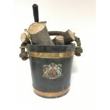 A wooden fire bucket with two metal collars, a rope and leather handle, decorated with the royal