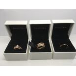 Three boxed Pandora dress rings.