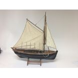 A model of a sailing ship with three sales on a stand.