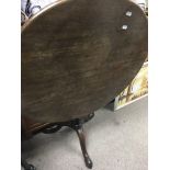 A Georgian mahogany tilt top table the circular top above a turned stem on pad feet