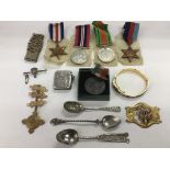 Four WW2 British medals plus a United British Empire medal, cap badges, silver vesta, spoons etc.