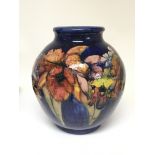 A large and impressive 1930s William Moorcroft signed vase with Orchid on a deep blue ground. No
