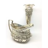 An ornately decorated silver jug, hallmarked for L