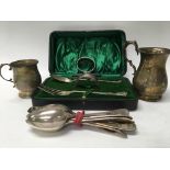 A collection of silver comprising two mugs cased fork and spoon two napkin rings and single silver