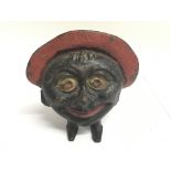 A cast iron money box of a comical figure.