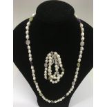 A long, single strand cultured pearl necklace and bracelet set with silver clasp