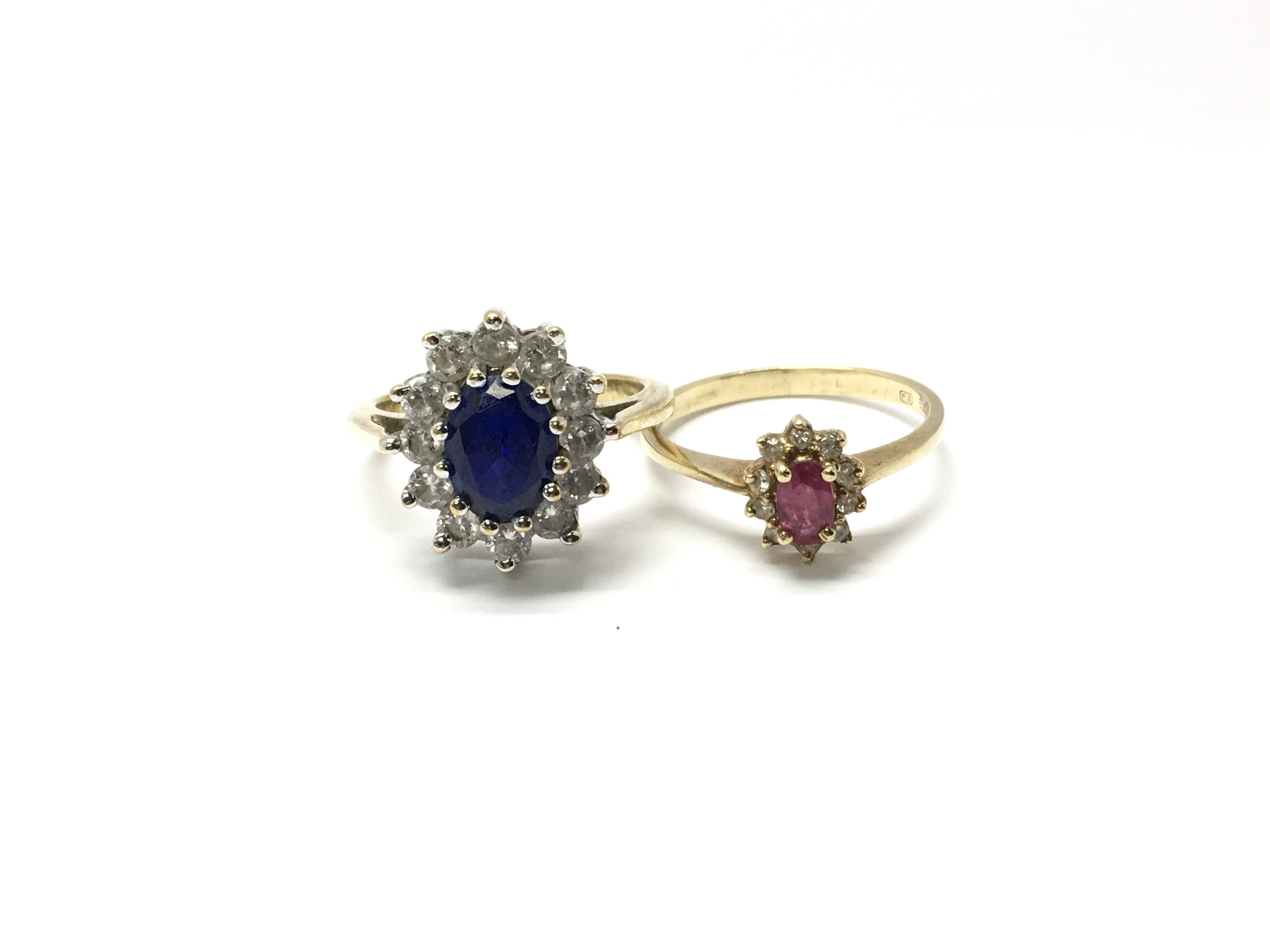 Two ladies 9ct gold and stone set rings, one with a central red stone surrounded by white stones and