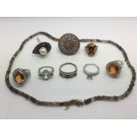 A collection of costume jewellery rings and a necklace.