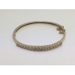 A 14ct gold bangle set with diamonds, approx 1.25c