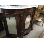 A Victorian marble top credenza with central mirror cupboard flanked by a further pair of mirrored