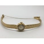 A lady's gold Longines watch on woven strap