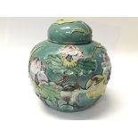 A Chinese ceramic ginger jar decorated with raised relief with Lilly and birds height 14cm no