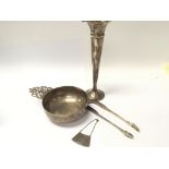 A white metal dish with scroll handles a pair of Silver sugar tongs and label.