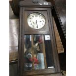 An oak wall clock with a silvered dial and visible pendulum - NO RESERVE