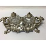 A Victorian silver inkwell stand of scrolled form inset with two ink bottles with silver lids