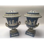 A Pair of late 19th Century Wedgwood jasper ware classical urns decorated with putti. Damage to