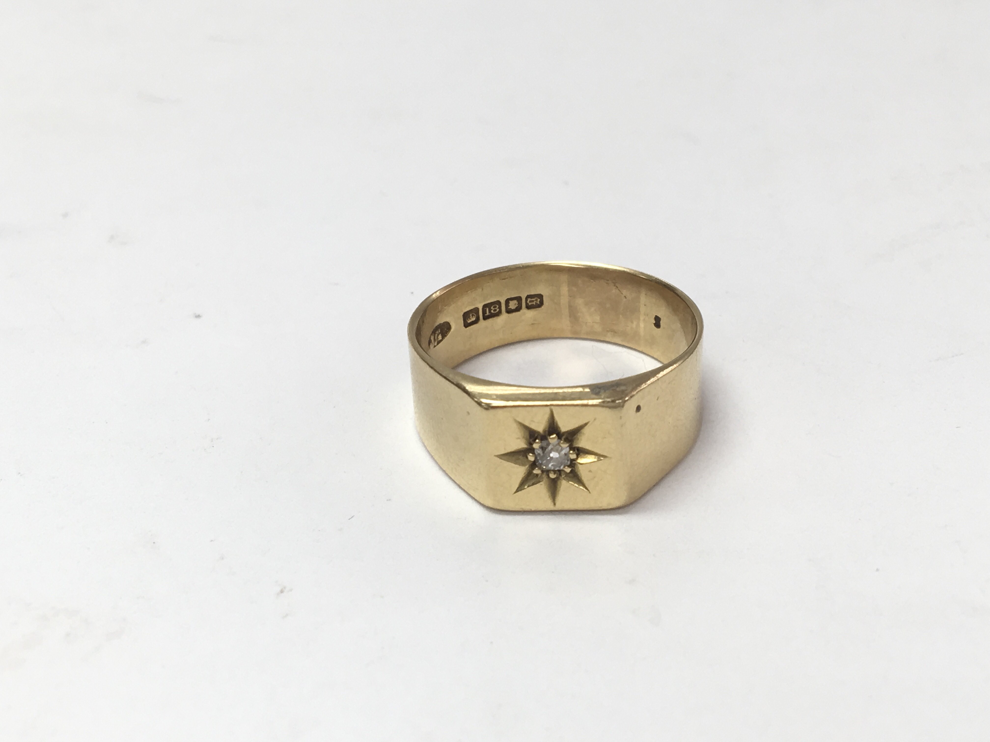 An 18ct gold gents ring set with a small diamond. Si