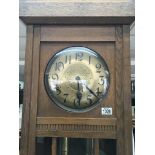 A 1920s oak longcase clock with a hammered finish brass dial and visible weights. Height 215cm