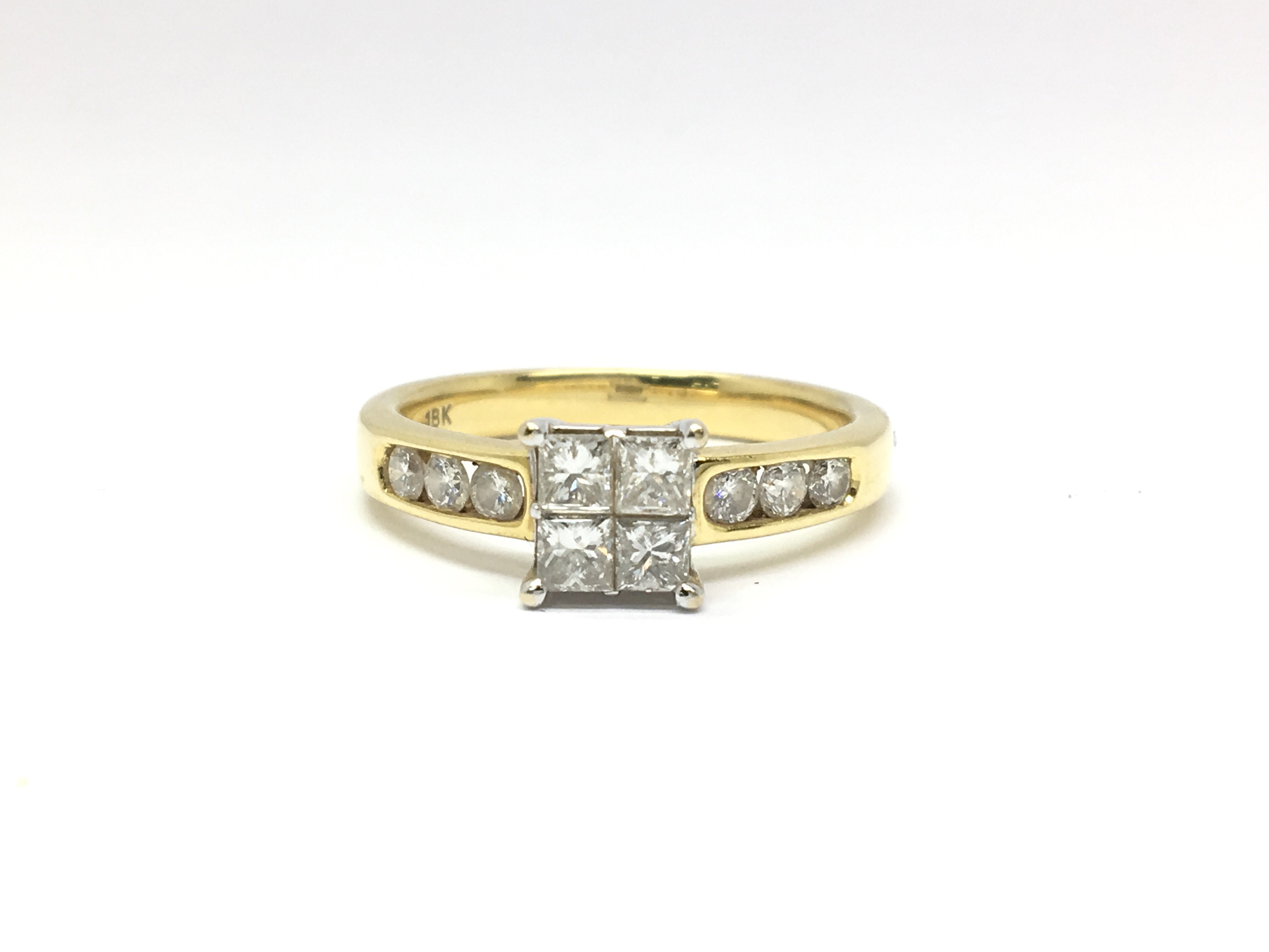 An 18ct yellow gold ring set with four central diamonds in a square formation, flanked either side
