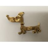 A Quality 18carat gold brooch in the form of a dog with reversing head and ruby and sapphire eyes