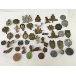 A collection of military cap badges including German examples