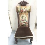 A Victorian prayer chair with floral tapestry style back.