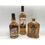 Three bottles of whiskey comprising The Famous Grouse, Chivas Regal and Canadian Club Classic.