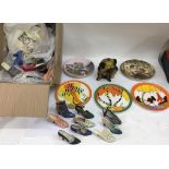 A box containing miniature shoes and collector's plates