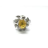 A ladies white metal ring set with a central yellow citrine surrounded by diamonds, ring size L,