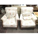 A pair of upholstery satin walnut arm chairs with cream and floral material.