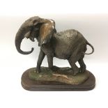 An ornamental figure of an elephant, no tusks, on a wooden plinth - NO RESERVE