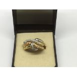An unusual 18ct gold three band ring of yellow and white gold set with diamonds.Approx O, 8g