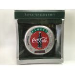 A boxed Coca Cola bottle top clock radio.