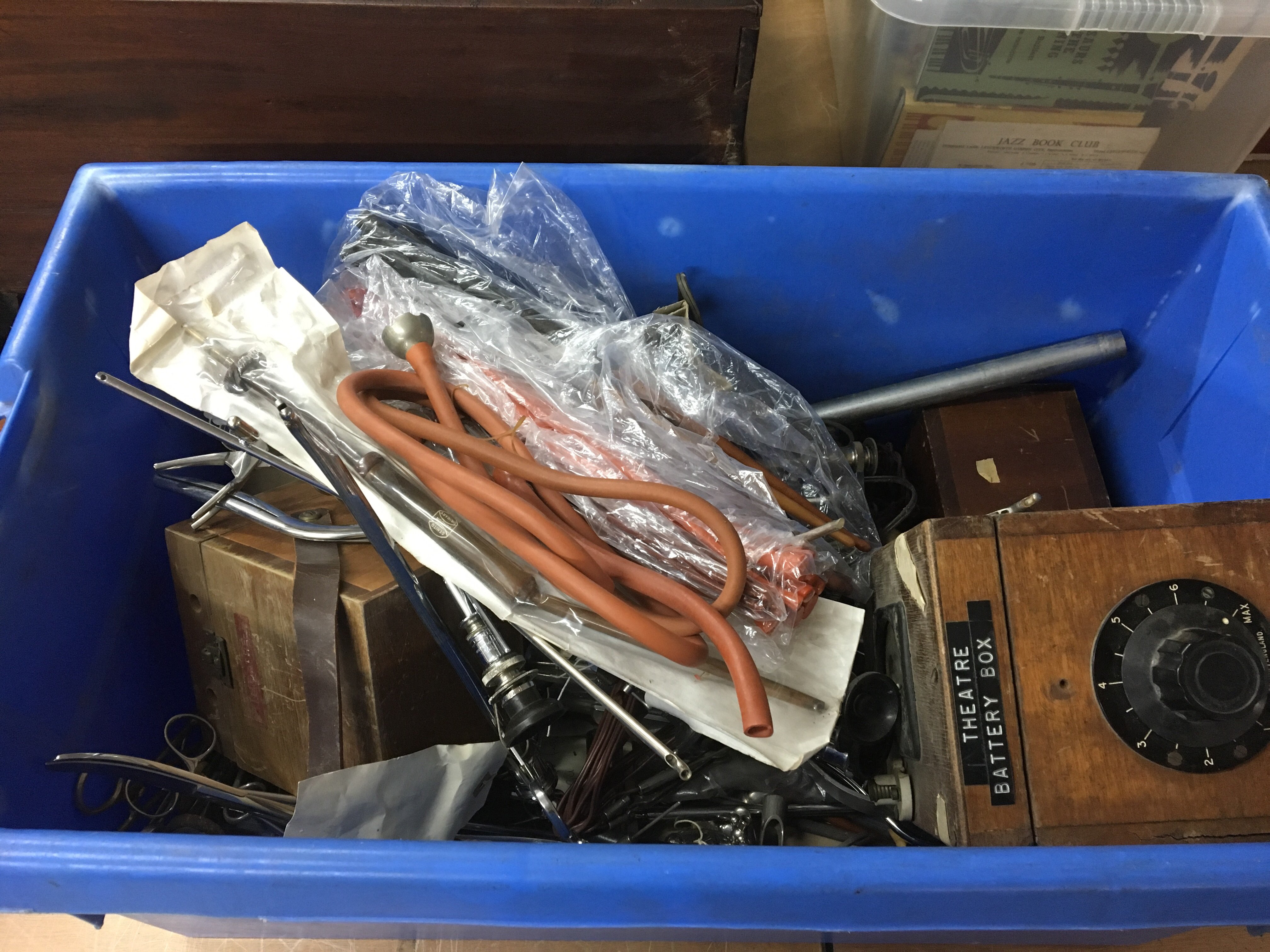 A box containing a collection of vintage medical surgeon and other medical instruments.