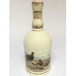A bottle of The Famous Grouse whisky in a ceramic
