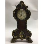 A small wooden clock decorated with gilt metal mou