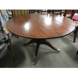 A circular mahogany breakfast table raised on bras