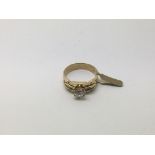 A modern style gold ring set with a clear stone, a