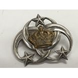 A small silver brooch mounted with a Royal Crown -