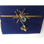 An Edwardian, gold spider brooch with blue glass b