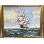 A gilt framed oil painting of a sailing ship at sea, approx 76cm x 66cm.