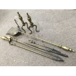 A set of three brass fire irons and matching fire dogs