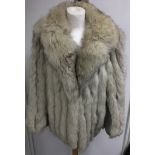 A vintage, cropped white fur jacket with grey leather arm panels.Approx 10-12