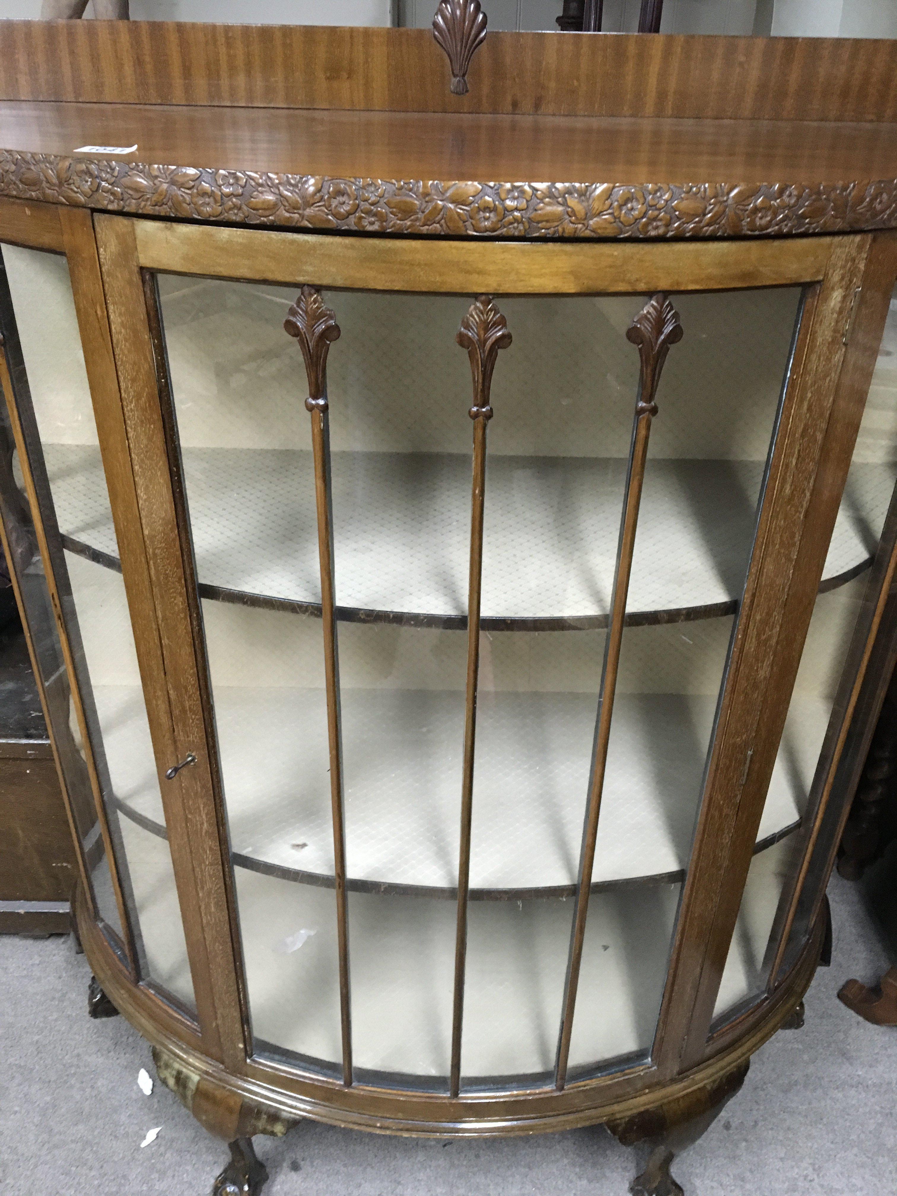 A walnut semi circular display cabinet on cabriole