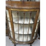 A walnut semi circular display cabinet on cabriole