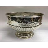 A silver punchbowl with embossed horseracing decoration above a half gadrooned body, approx 1kg, app